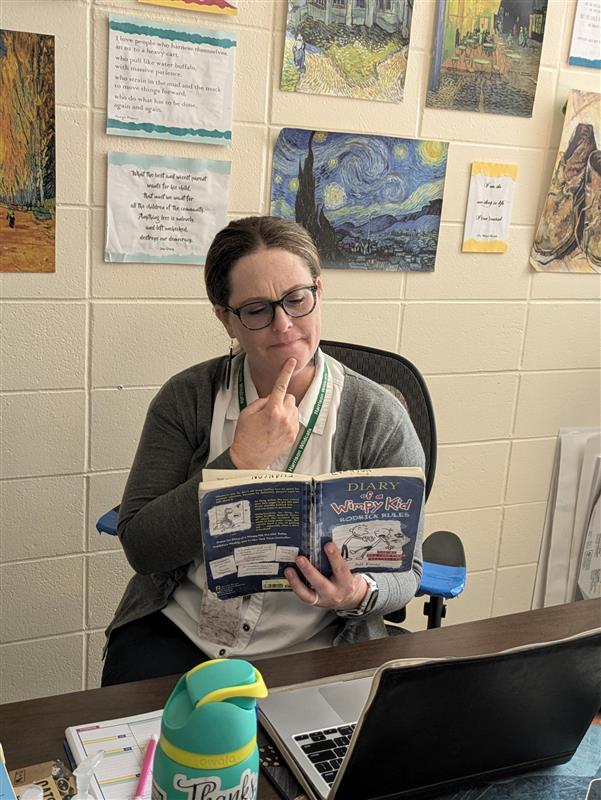 Ms. Evanson pondering the bigger questions of life reading the sophisticated "Rodrick Rules"