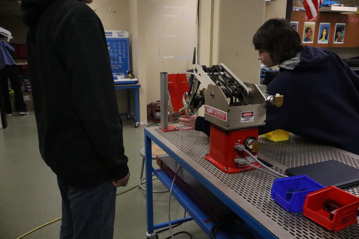 Adv Manufactuing student making sure the robot is holding the block correctly.