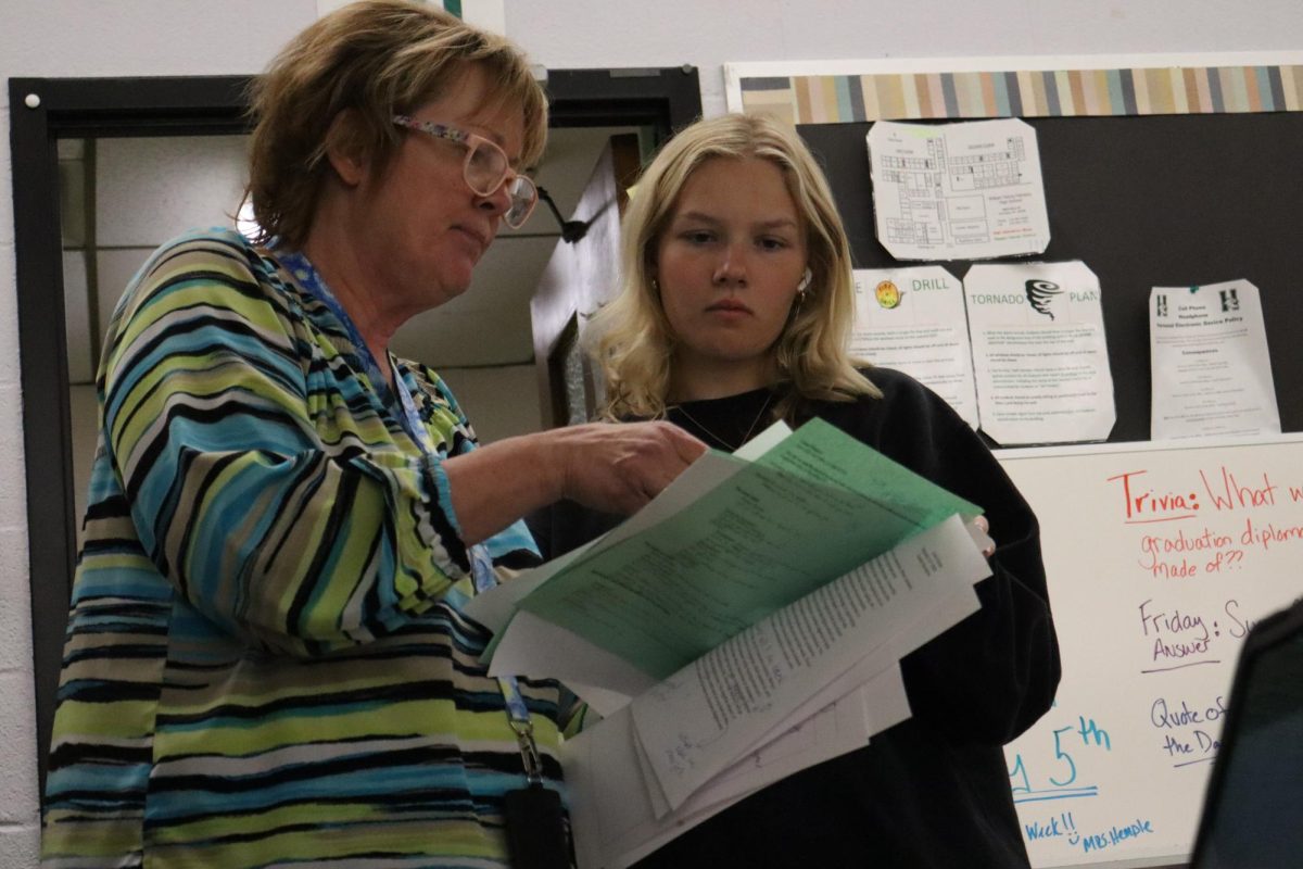 Mrs. Hinterlong helping a student with her career passport. 
