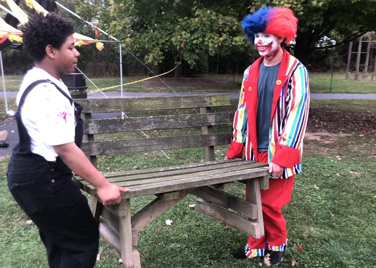 Two scare actors moving a wooden bench