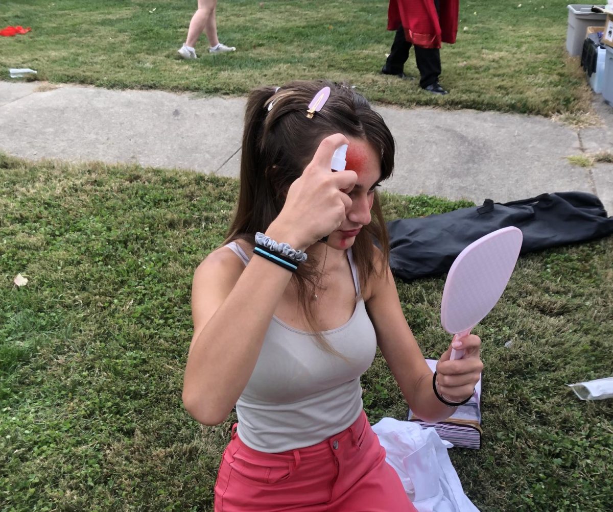Emily Benight spraying fake blood on her face