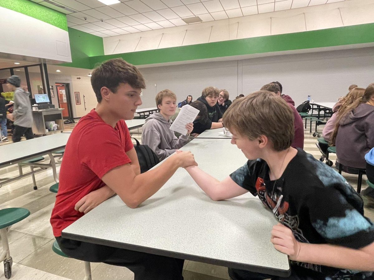 Stewart losing an arm-wrestling match with unknown and stronger opponent. 