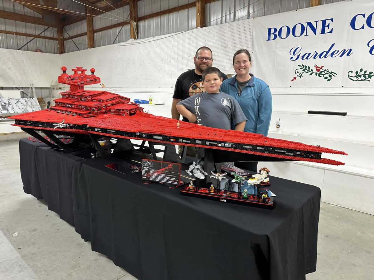 Brian Egan standing behind his Errant Venture with his wife and son.