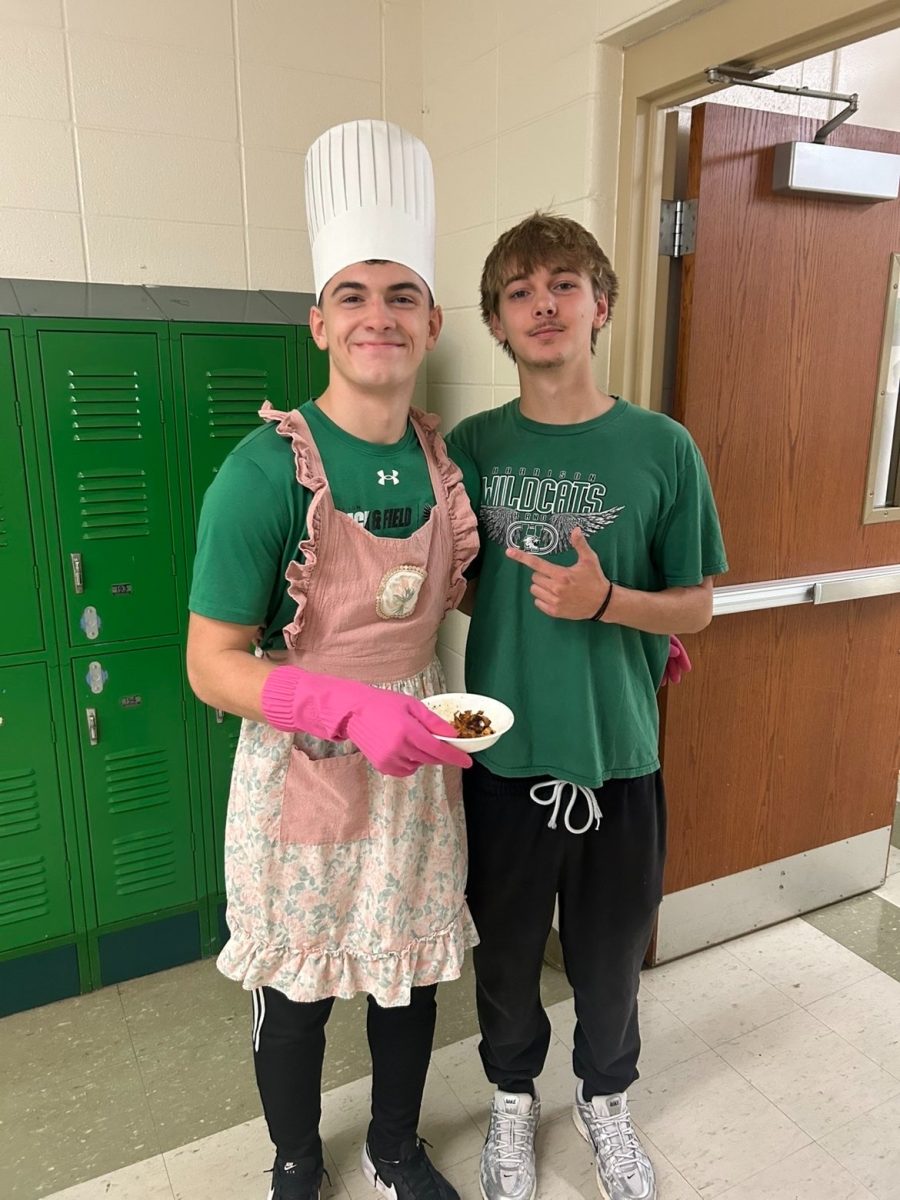 Adrian Krull, in his signature hat and apron, poses in the hallway with Matt Finley and some delicious food.