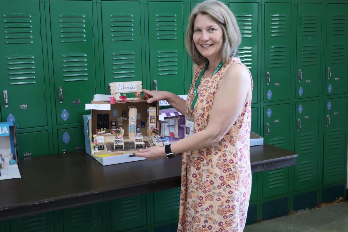 Sra. Martini holding up one of her student's dioramas originally created for a Spanish 3 project.